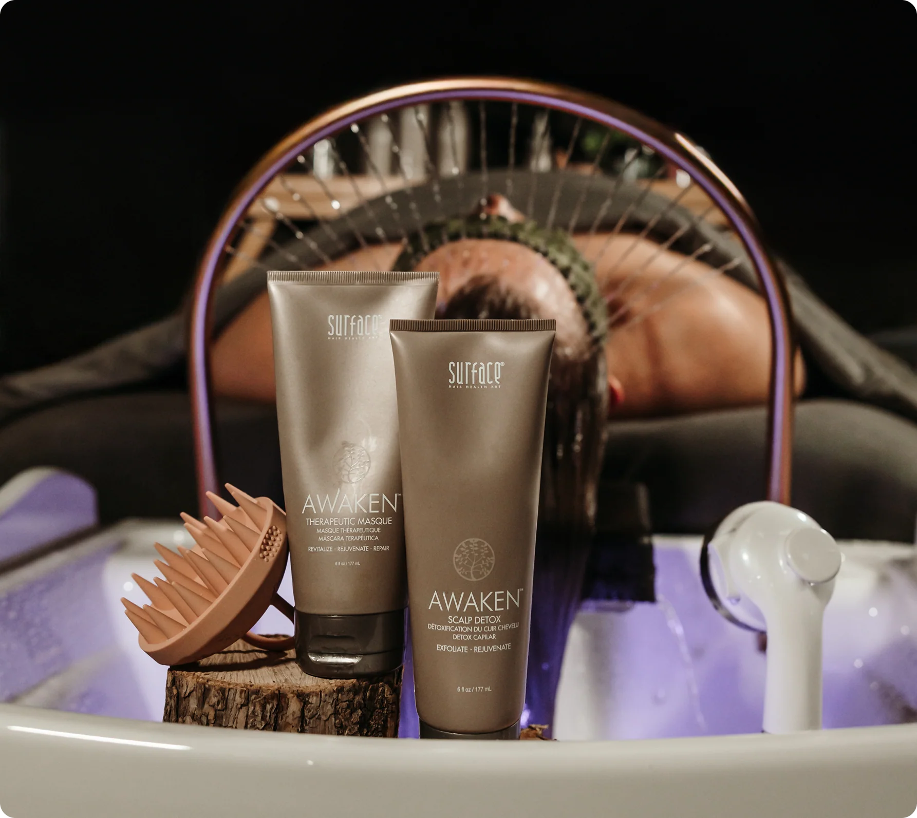 Surface Awaken scalp products beside a guest receiving a head spa treatment